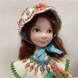 Anna Meszaros Hungary - three hand made needlewrok figurines - each wearing a lon floral dress and bonnet and holding a bouquet of flowers, tallest H32cm (3)  Auctioneer's Note: Anna Meszaros came to England from her native Hungary in 1959 to marry an English businessman she met while demonstrating her art at the 1958 Brussels Exhibition. Shortly before she left for England she was awarded the title of Folk Artist Master by the Hungarian Government. Anna was a gifted painter of mainly portraits and sculptress before starting to make her figurines which are completely hand made and unique, each with a character and expression of its own. The hands, feet and face are sculptured by layering the material and pulling the features into place with needle and thread. She died in Hull in 1998.