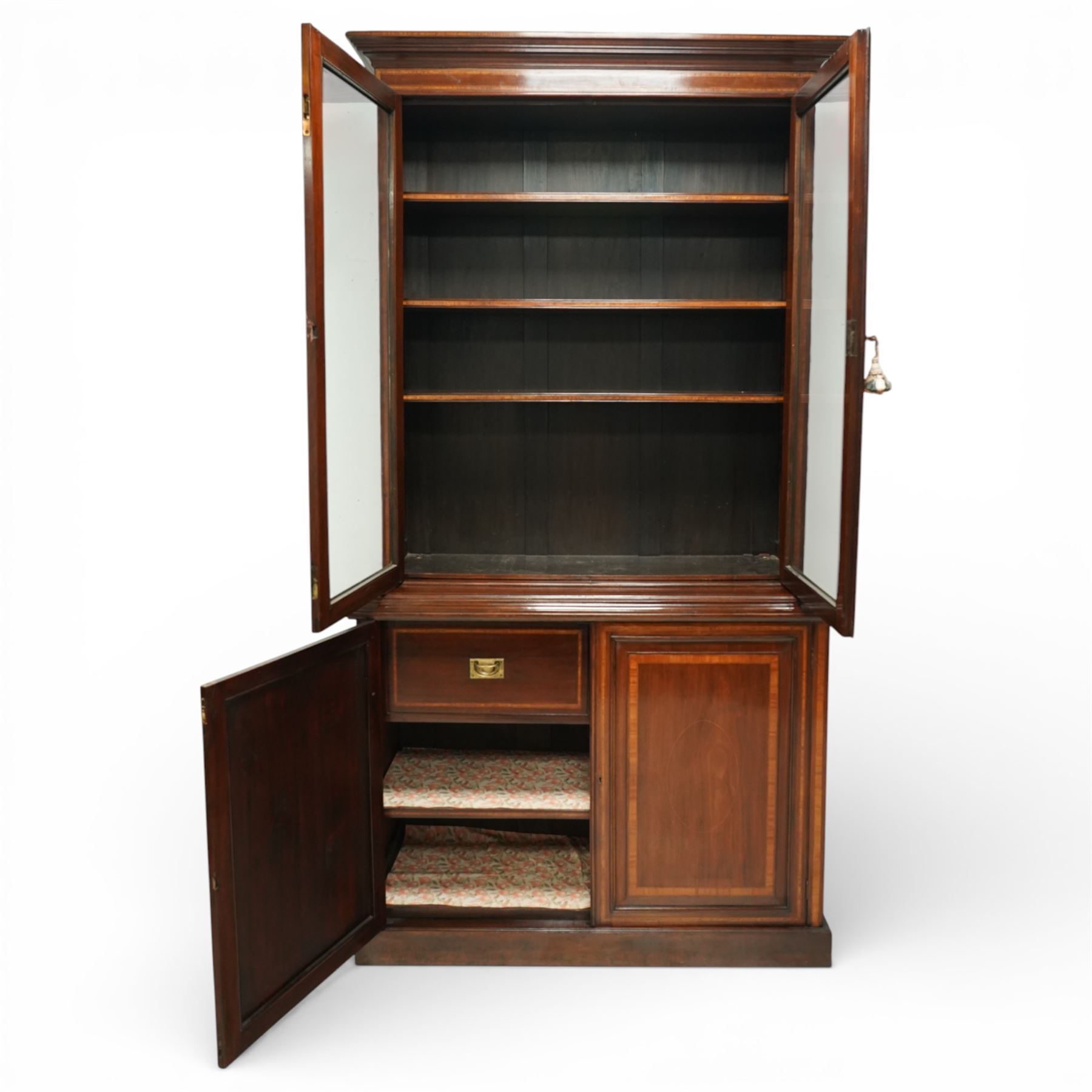 Large Edwardian walnut and satinwood enclosed bookcase-on-cupboard, projecting cornice over two glazed doors with satinwood and ebony banding and stringing enclosing three adjustable shelves, over two panelled doors enclosing two drawers above shelf, on skirted base