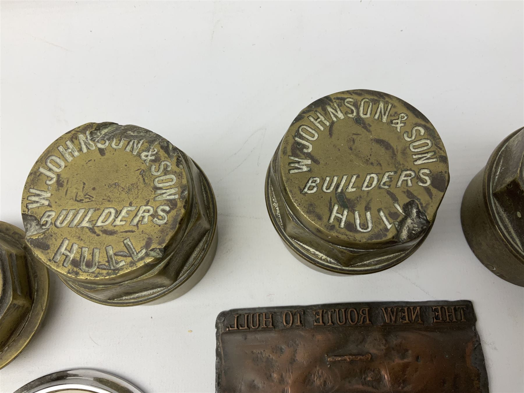 Three brass cart wheel hub caps for W. Johnson & Son Builders Hull, another for W. Harrison Builder Hull, copper printing plate for Hull & Barnsley Railway Timetable, two Hull & District Road Transport Training Group Advanced Driver car badges and framed 1952 car road task disc (8)  