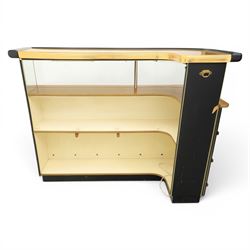 Barget of London - Mid 20th century L-shaped teak and black vinyl cocktail bar, shaped top with gilt metal banding and black cushioned edge over glazed upper section and open serving shelf, the reverse fitted with shelves, the front with applied lattice mouldings over black vinyl, on plinth base