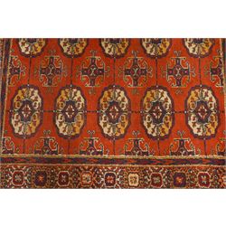Two hand-knotted rugs, comprising Turkoman Ersari rug and Bokhara rug, Turkoman Ersari hand-knotted rug, terracotta ground with two rows of repeating octagonal guls interspersed with geometric motifs, enclosed by multiple geometric borders, fringed ends, H125cm, W93cm; Bokhara hand-knotted rug, madder red ground with three rows of repeating Tekke guls interspersed with geometric motifs, enclosed by multiple stylised floral and geometric borders, fringed ends, H188cm, W126cm