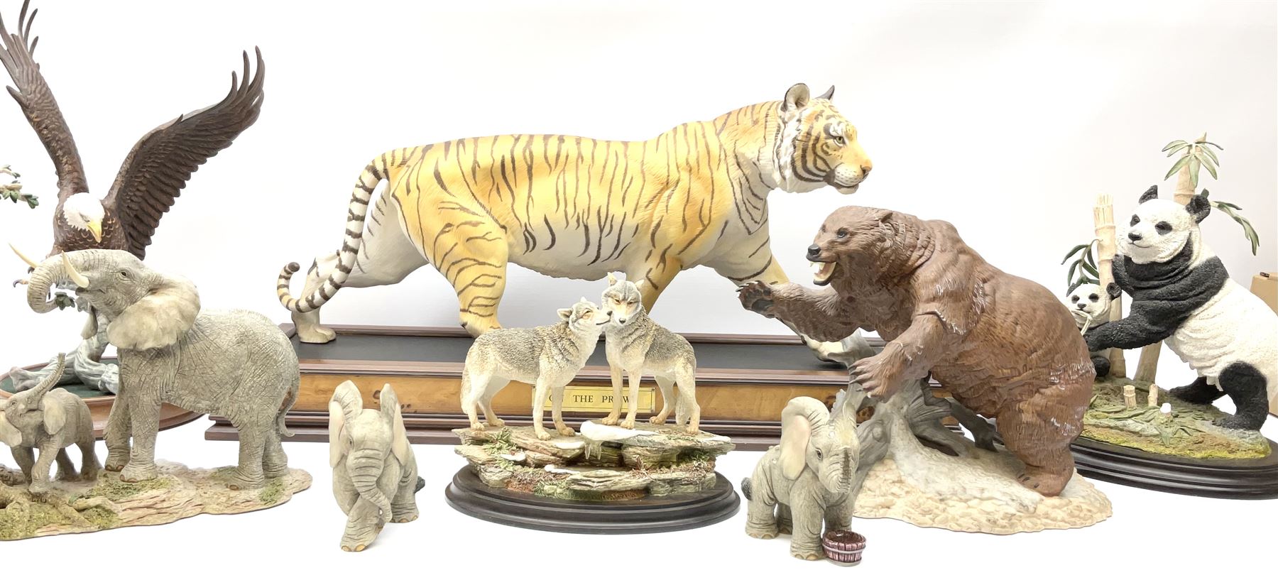 Three Franklin Mint figures, first example On The Prowl, on wooden stand H32cm, L63.5cm, Grizzly, H23cm and American Majesty by Ronald Van Ruyckevelt H37cm, together with five other figures.  