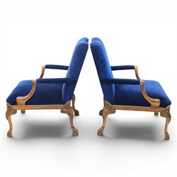 Pair of George II design Gainsborough armchairs in deep blue upholstery, shaped back over scrolled and carved arms, with cabriole supports and carved shell knees terminating in claw on ball feet