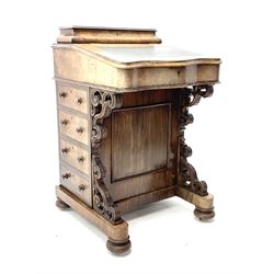 Victorian walnut Davenport, raised pen and ink compartment over sloped hinged top with inset writing surface, birds eye maple interior fitted with small drawers and pigeon holes, right-hand side fitted with four drawers, left-hand side with four false drawers, pierced and scroll carved brackets, on sledge supports with turned bun feet with recessed castors