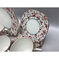 Windsor tea service for six decorated with blooming pink roses and purple flowers amongst foliage