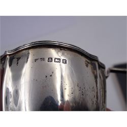 Edwardian silver cream jug, of fluted helmet form, with angular handle and upon shaped foot, hallmarked Birmingham 1905, maker's mark indistinct, together with a set of six Edwardian silver teaspoons and a pair of sugar tongs, all with scrolling embossed decoration and engraved monogram, hallmarked Joseph Rodgers & Sons, Sheffield 1903, within tooled leather fitted case, jug including handle H9cm 