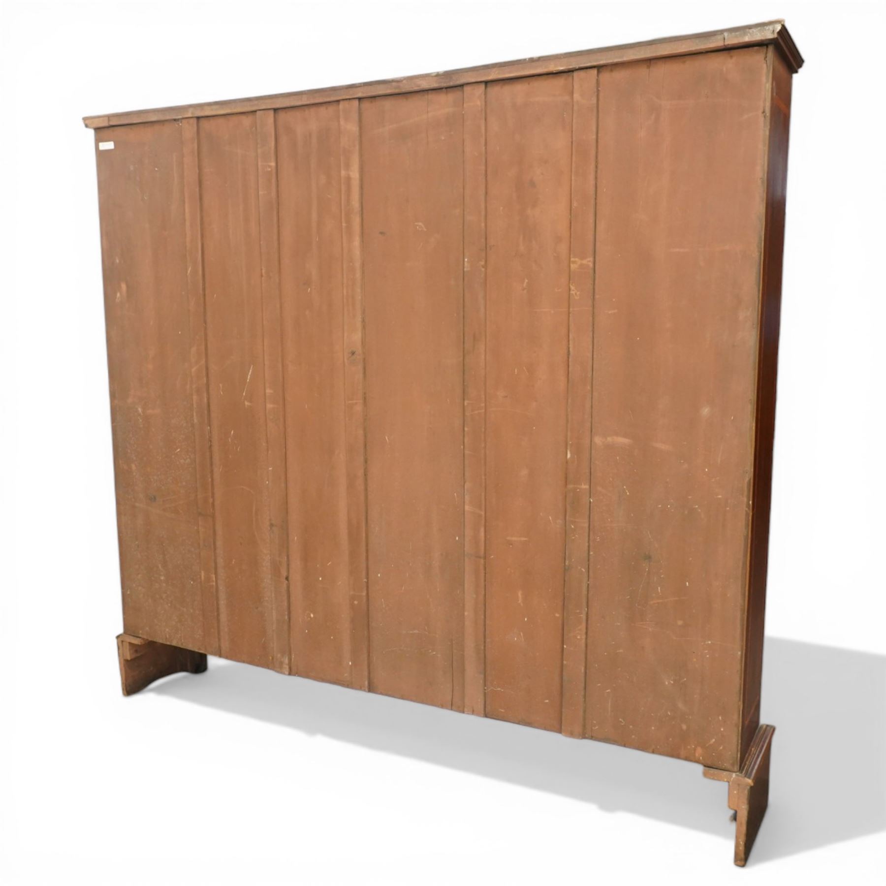 Quality Edwardian inlaid mahogany triple-column open bookcase, projecting cornice over a satinwood banded frieze, fitted with fourteen adjustable shelves with strung facias, the shaped apron on bracket feet
