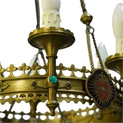 Gothic Revival brass six-light ecclesiastical chandelier, circular frame with pierced trefoil cresting and apron, applied with polychrome Sacred Heart medallions, six candle-form electric sconces, suspended on twisted brass rods and chains from a coronet-form ceiling boss