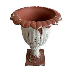 Early 20th century terracotta garden urn, the body and rim in the form of rising and splayed leaves, on moulded footed base with further leaf decoration