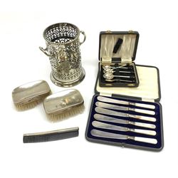 A pair of silver mounted clothes brushes, each with engine turned detail and monogramed central panel, and silver comb mount, all hallmarked Adie Brothers Ltd, Birmingham, date letters worn and indistinct, together with a cased set of six mother of pearl knives with silver ferrules, hallmarked William Yates Ltd, Sheffield 1916, a silver plated bottle coaster, with pierced sleeve and twin handles, marked beneath for Daniel and Arter, Birmingham, and a set of six silver plated coffee bean spoons. 
