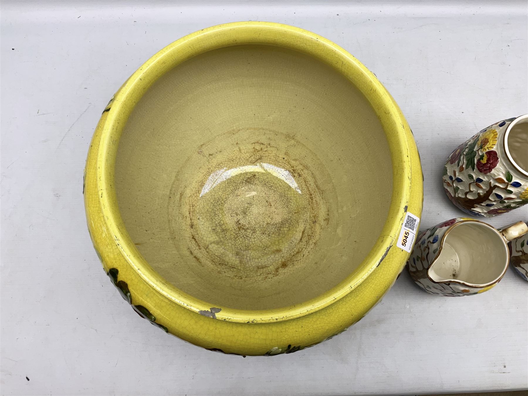 Victorian Leeds Art Pottery jardinière decorated with flowers and foliage on a brown and yellow merging ground, together with H.J. Wood Indian Tree jugs and vase, jardinière D37cm