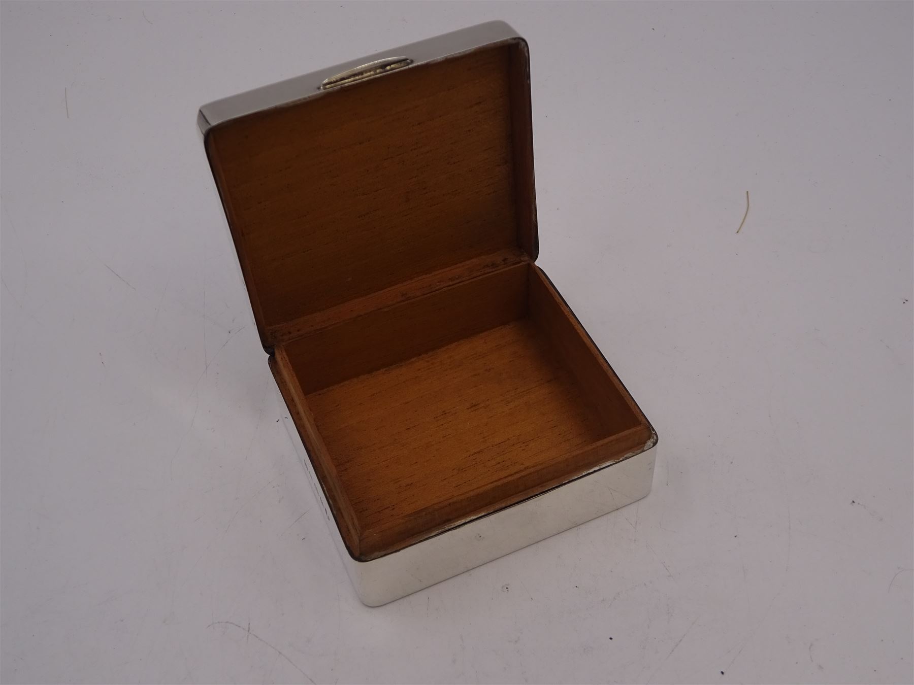 1930s silver mounted cigarette box, of square form, with engine turned decoration and blank rectangular panel to hinged cover, opening to reveal softwood lined interior, hallmarked William Neale & Son Ltd, Birmingham 1934, H3.8cm