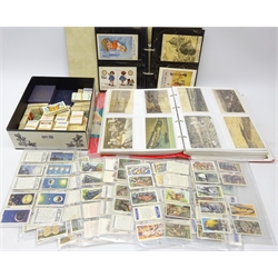  Collection of postcards including topographical, comical, ethnic etc in two ring binder albums, various cigarette cards including John Players & Sons, playing cards and tea cards  