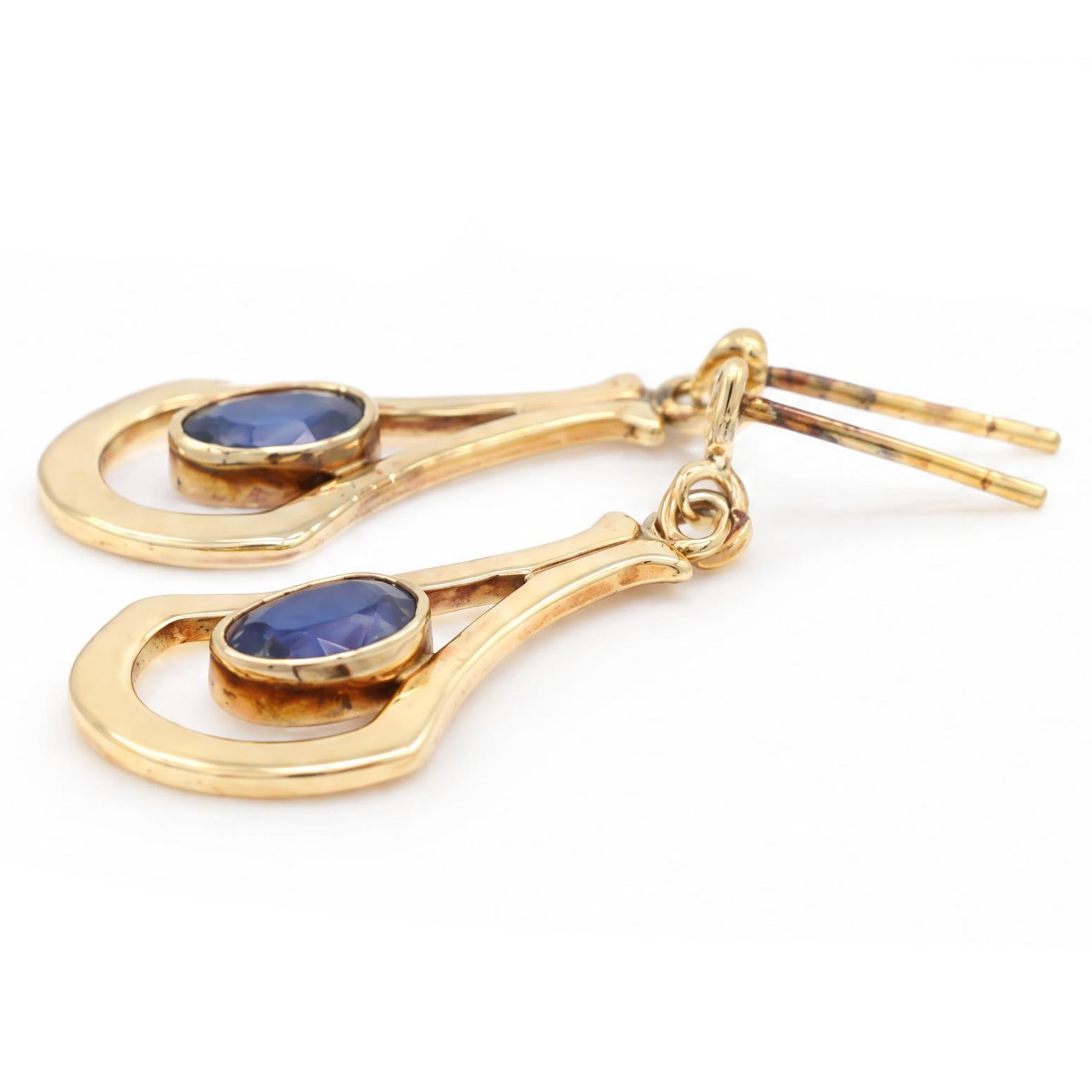 Pair of 9ct gold sapphire pendant earrings, each stud set with a single oval cut sapphire, in an openwork setting