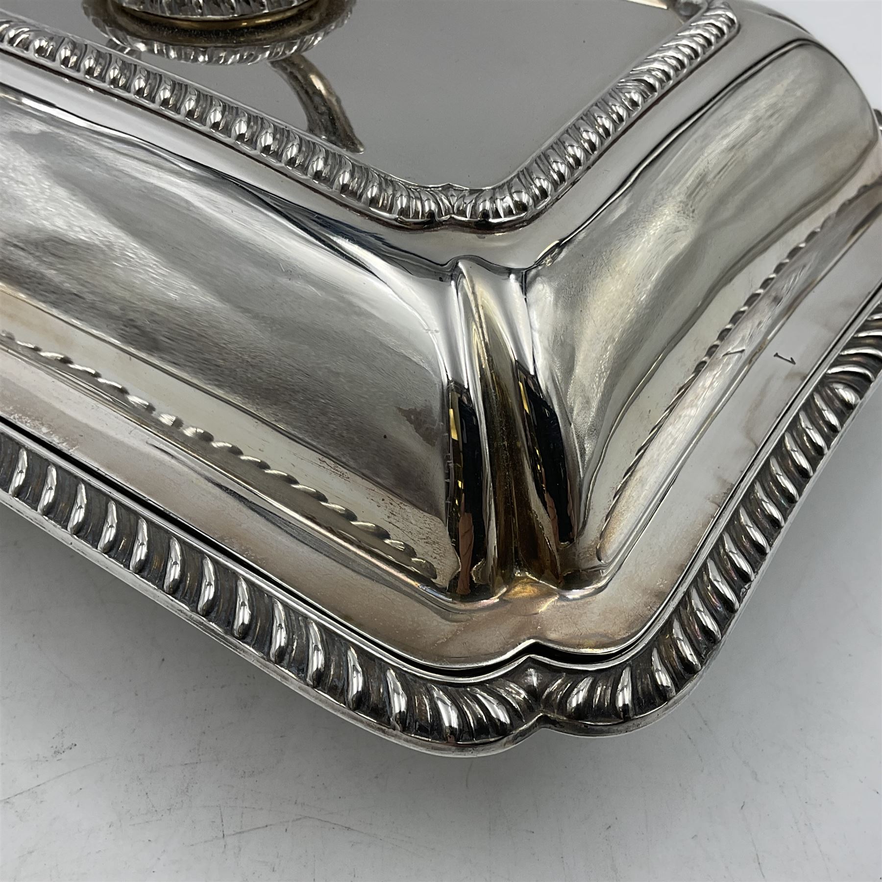 Early 20th century silver entree dish and cover, of rectangular form with shaped corners and oblique gadrooned borders to base and cover, the cover with loop 'bamboo' handle, hallmarked Thomas Bradbury & Sons Ltd, Sheffield 1930, including handle H10.5cm L24.5cm