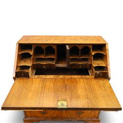 18th century figured walnut bureau, the sloped fall-front enclosing fitted interior with sliding base, pigeon-holes and correspondence drawers with shaped facias, over two short and two long feather-banded drawers with pressed brass handle plates, on bracket feet