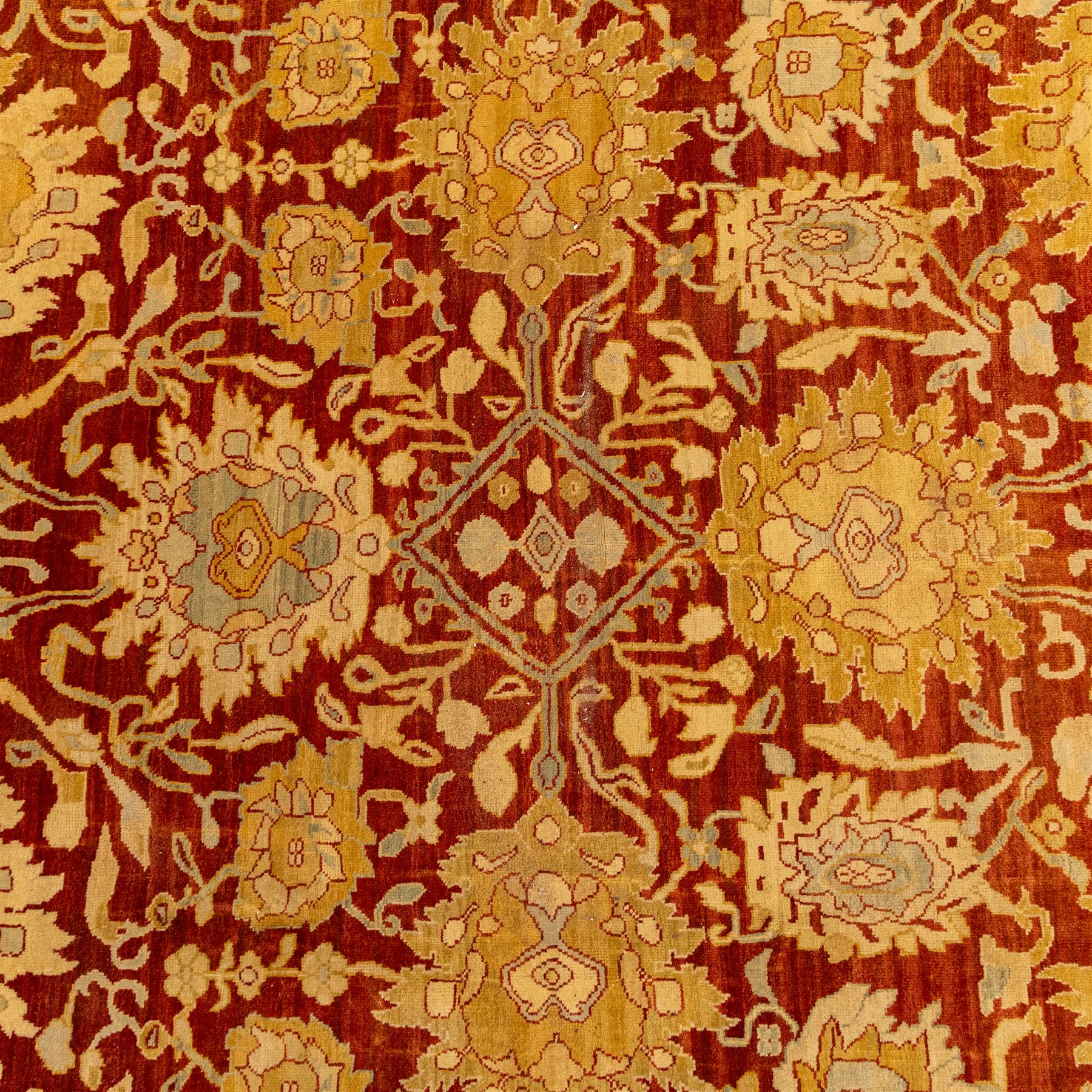 Central Persian Ziegler design hand-woven carpet, rich madder red field with central stylized lozenge medallion enclosed with an all-over lattice of scrolling vine, palmettes, and angular floral motifs of the Sultanbad tradition, broad ivory main border decorated with large-scale rosettes and flowering cartouches, flanked by narrow guard stripes, with fringe ends 