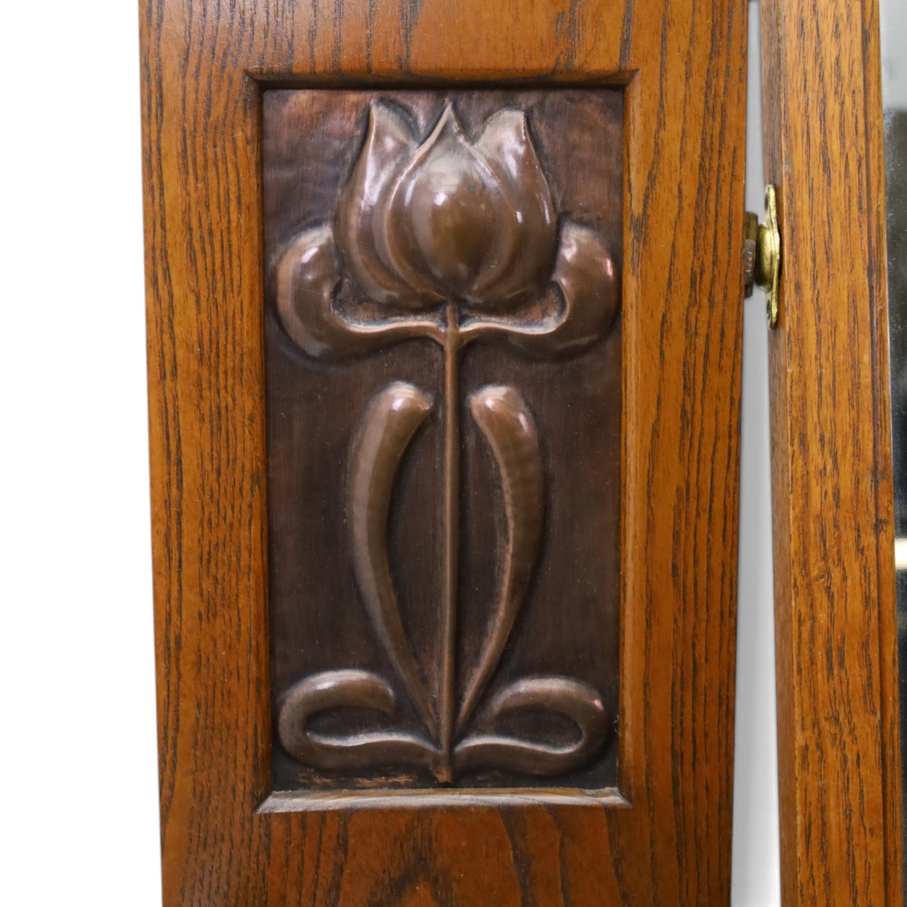 Shapland & Petter - oak mirrored dressing chest, tilted mirror flanked by tulip carved supports, shaped shelves with heart cut outs, above two short over one long drawers, with brass handles and stamped S & P on the locks, raised on shaped supports