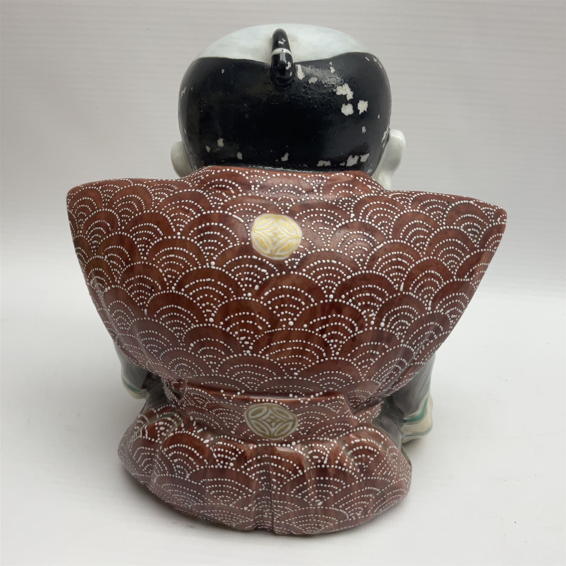 Japanese Fukusuke good fortune figure, modelled as a kneeling male figure holding a fan, dressed in traditional Samurai robes, H15.5cm