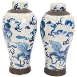 Pair of 20th century Chinese crackle glaze vases, of baluster form, decorated with dogs of foo amongst clouds, H23cm
