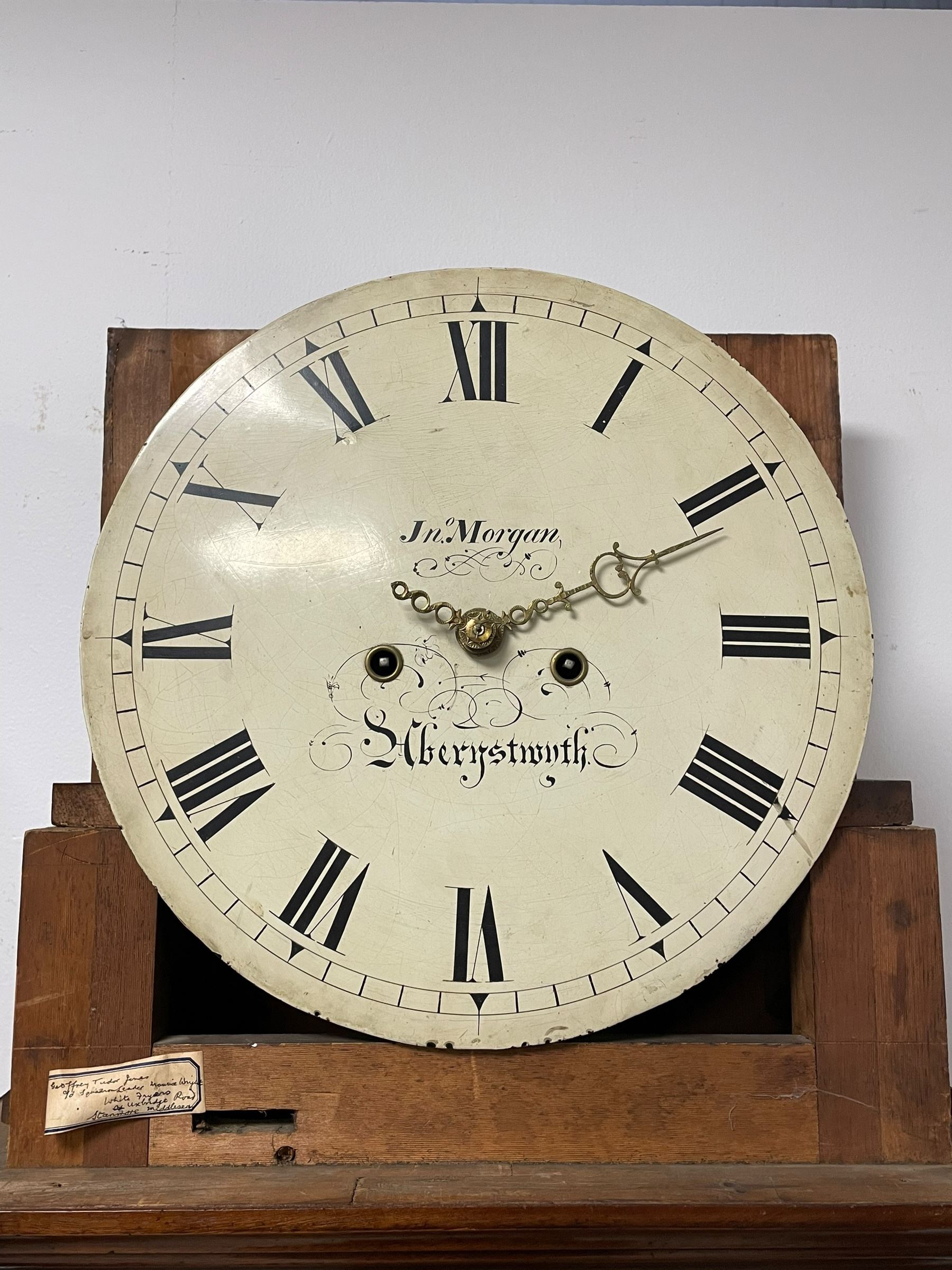 John Morgan of Aberystwyth - fine George IV mahogany 8-day longcase clock c1820, with a raised swan necked pediment, ball and eagle finial and deep inlaid frieze beneath, square hood door with a glazed circular wooden bezel and canted corners, long trunk with reeded quarter columns and a wavy topped door, rectangular plinth on bracket feet, circular painted dial with Roman numerals, minute track, makers name, and brass stamped hands, rack striking four pillar movement with a recoil anchor escapement, striking the hours on a bell. With weights and pendulum. 
John Morgan is recorded as working in Aberystwyth 1816-35. 