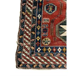 Turkish red ground rug, decorated with three medallions and geometric motifs, four band border with geometric design
