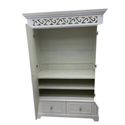 White painted double wardrobe, pierced scrolling foliate frieze over two doors enclosing hanging rail and two shelves, two drawers fitted to base, with blue ceramic handles