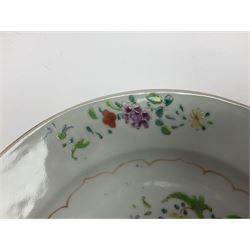 Three 18th century Chinese Famille Rose plates, the first example enamelled with blossoming peonies, rockwork and fence, the other two examples of similar design, decorated with blossoming peonies and sprigs within shaped inner borders, each approximately D23cm