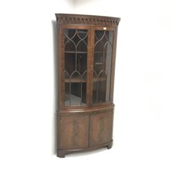 Bevan Funnel Reprodux mahogany double corner cabinet, projecting cornice, dentil frieze, two astragal glazed doors enclosing two shelves above single slide, two cupboard doors, bracket supports 