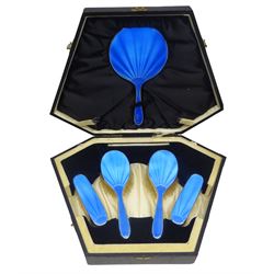 Art Deco thirteen piece silver mounted blue guilloche enamel dressing table set, comprising two hair brushes, two clothes brushes, hand mirror, two cut glass jars, buffer and a cut glass scent bottle, hallmarked J W Tiptaft & Son Ltd, Birmingham 1930 and 1932, and a silver handled manicure set, hallmarked Daniel Manufacturing Company, Birmingham 1930, with a pair of base metal scissors, each contained within three original fitted cases with black and cream silk and velvet lined interiors, one with removable mirror