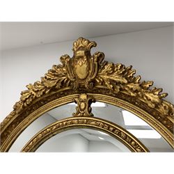 Gilt Rococo style mirror, arched top with central cartouche and oak leaf moulded pediment, floral and fruit moulded surround with segmented glass panels, bevelled central pane, c-scroll shell and acanthus leaf brackets