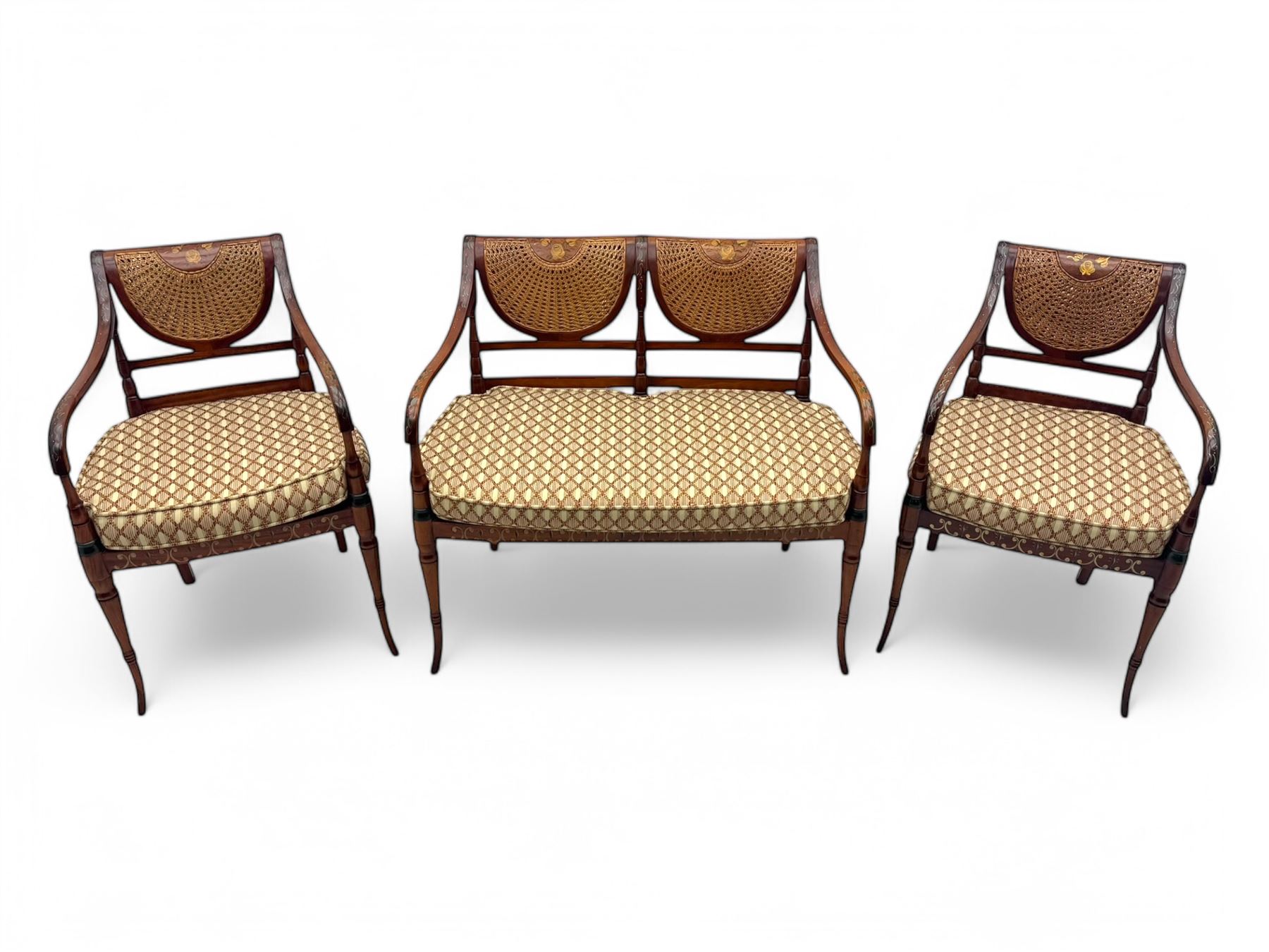 Edwardian Sheraton Revival inlaid mahogany parlour suite, comprising a two-seater settee and two matching armchairs, each with fan-shaped caned back, shaped crest rail with foliate inlay, scrolled open arms, upholstered seat with repeating geometric pattern, on turned and tapered front supports