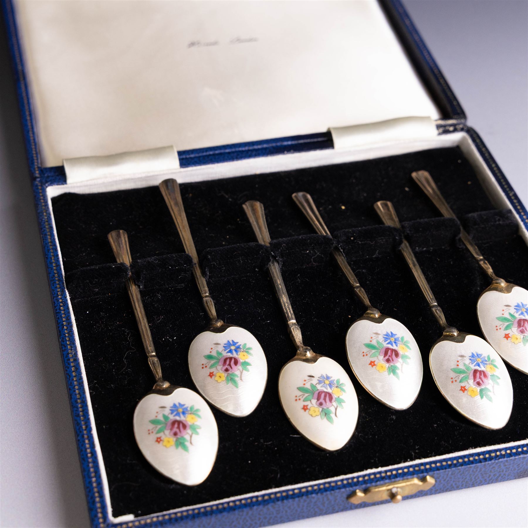 Set of six mid 20th century silver-gilt and guilloche enamel coffee spoons, the undersides of the bowls painted with colourful floral decoration, hallmarked Turner & Simpson Ltd, Birmingham 1960, within Harrods case