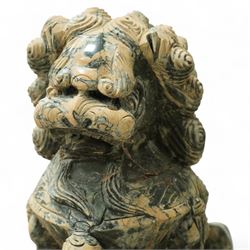 Pair of Chinese hardstone carved Foo dogs, each finely carved seated on rectangular plinth bases with detailed manes, collars and bells, the male with paw resting on a ball, the female with cub, in mottled green stone resembling jade