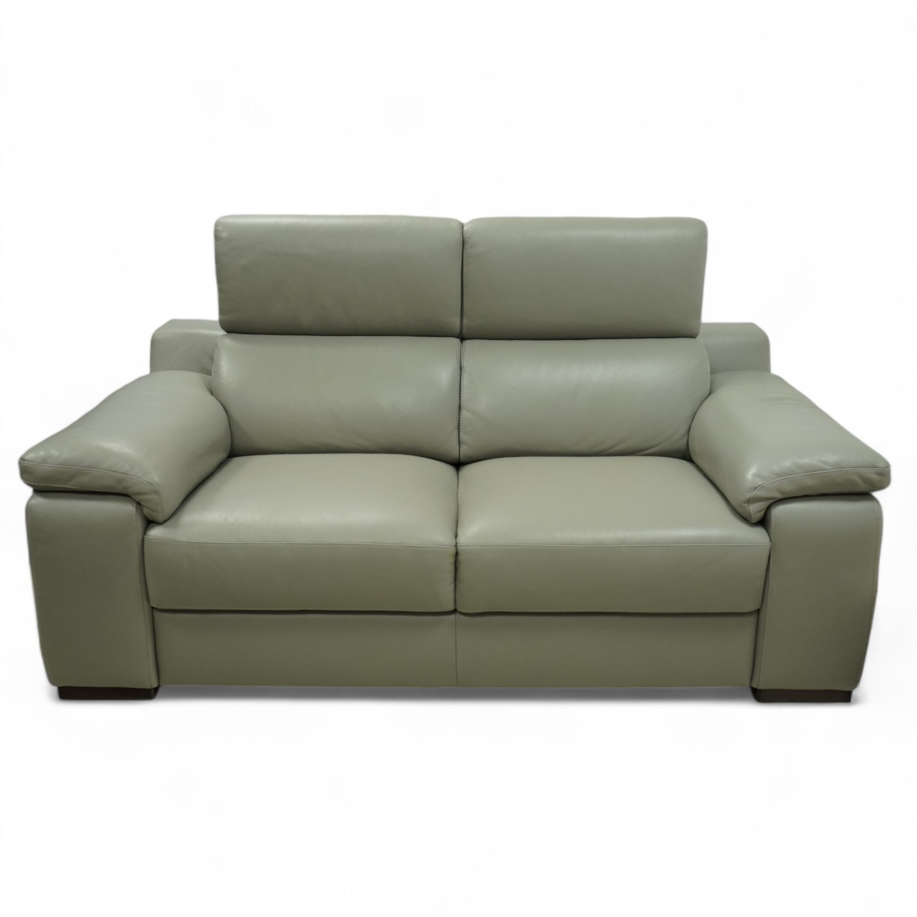 Modern Italian style leather two-seat sofa, upholstered in pale grey leather with panel stitched cushioning, with retractable head rests and broad arms, raised on square feet