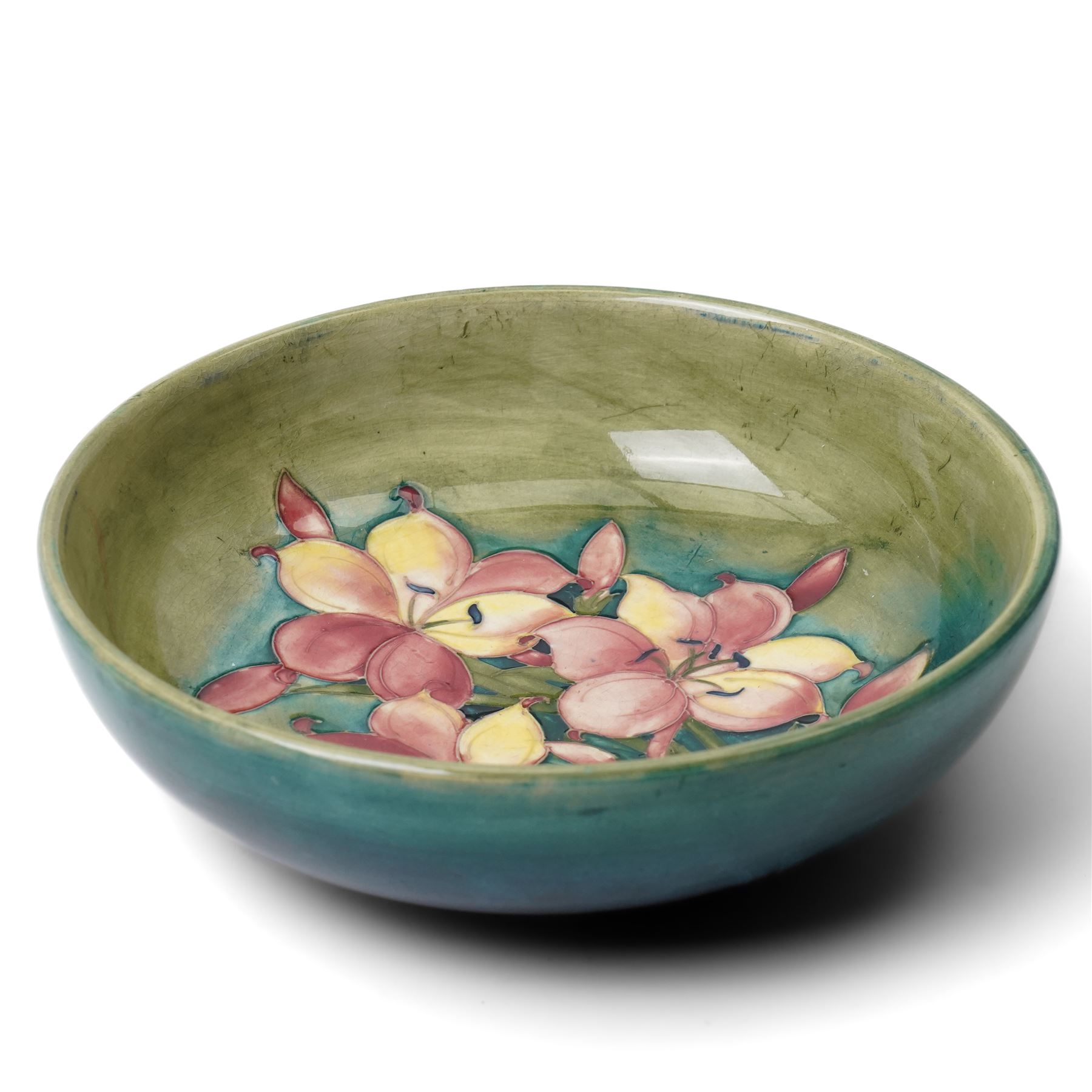 William Moorcroft African Lily pattern bowl, on a green ground, blue signature mark to base, D22cm