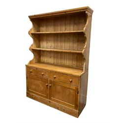 Early 20th century traditional pine dresser, two-tier plate rack with hooks, base fitted with two drawers over two cupboard doors