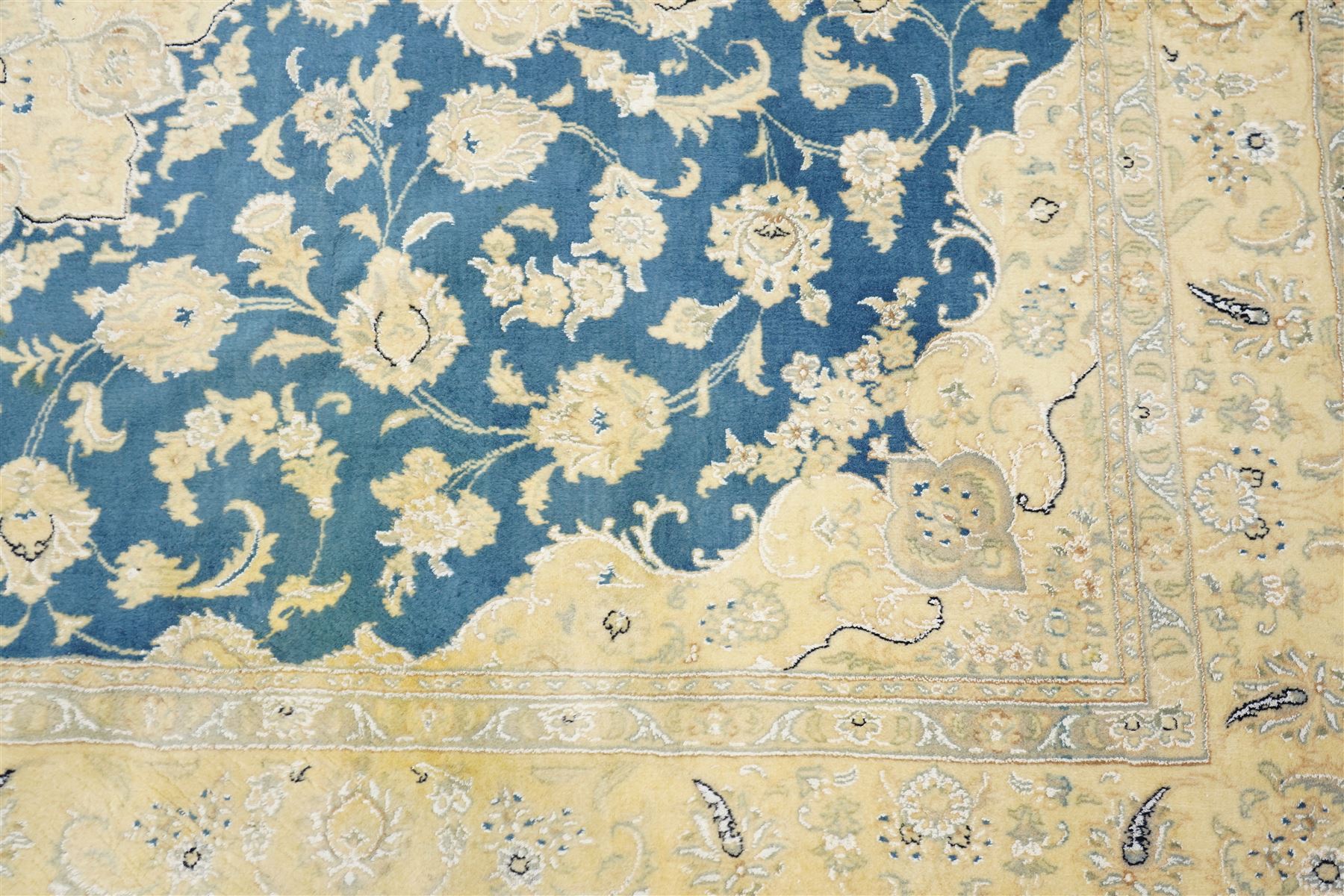 Central Persian Nain hand-knotted rug, sky blue field, with a central cusped medallion in ivory and soft camel tones, issuing an elegant arrangement of scrolling arabesques, palmettes and flowering vines, conforming ivory spandrels, principal pale border decorated with floral sprays and palmettes, flanked by narrow ground borders, with cotton fringe ends  