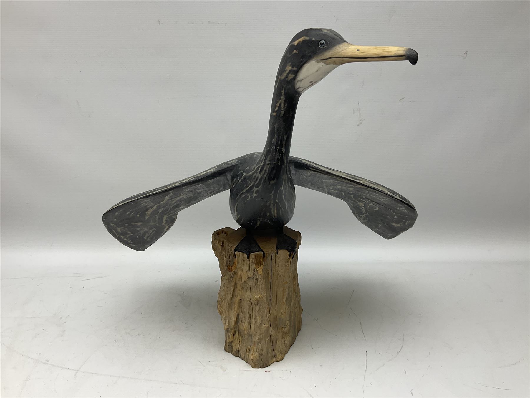 Wooden sculpture of Cormorant aquatic bird on a naturalistic wooden plinth, H46cm