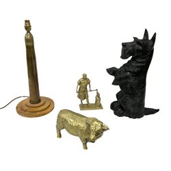 Cast iron doorstop modelled as a Scottie dog, brass model of a bull, brass model of a blacksmith and a brass shell converted into a table lamp on circular wooden base