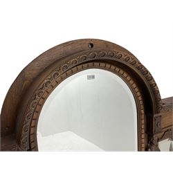 Late 19th century carved oak overmantle mirror, arched top with foliate carved edge and two turned acorn finials, triple bevelled plate front with carved figural pilasters decorated with fruit and trailing branch