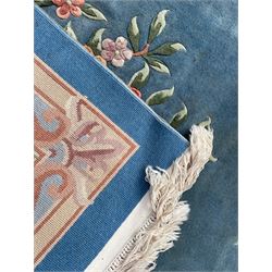 Large Chinese blue ground woollen carpet, overall floral design, central oval medallion surrounded by scrolling floral decoration, wide border with decorated with floral bouquets 