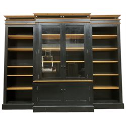 Contemporary polished pine and black finish break-front bookcase, projecting cornice over globular mounts, central cabinet enclosed by two glazed doors over double panelled cupboard, flanked by adjustable shelves, on plinth base
