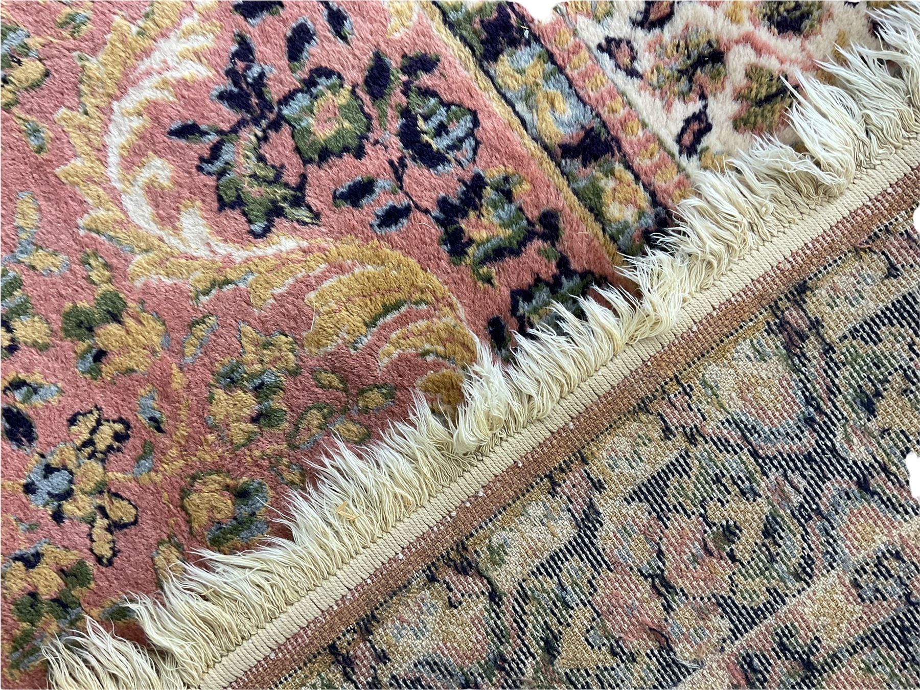 Large Persian design peach ground carpet, the field decorated with floral medallion, multi-band border decorated with repeating flower head pattern