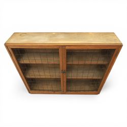 Rustic pine cupboard fitted with wire panelled doors, enclosing staggered adjustable shelving