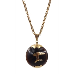 Gold mounted kukui nut pendant, on gold chain with barrel clasp stamped 9c 