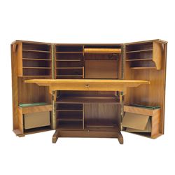 Mid-20th century walnut 'Magic Box' design metamorphic desk cabinet, two doors open to reveal sliding desk with drop leaves, document divisions and internal lamp, on sledge supports 