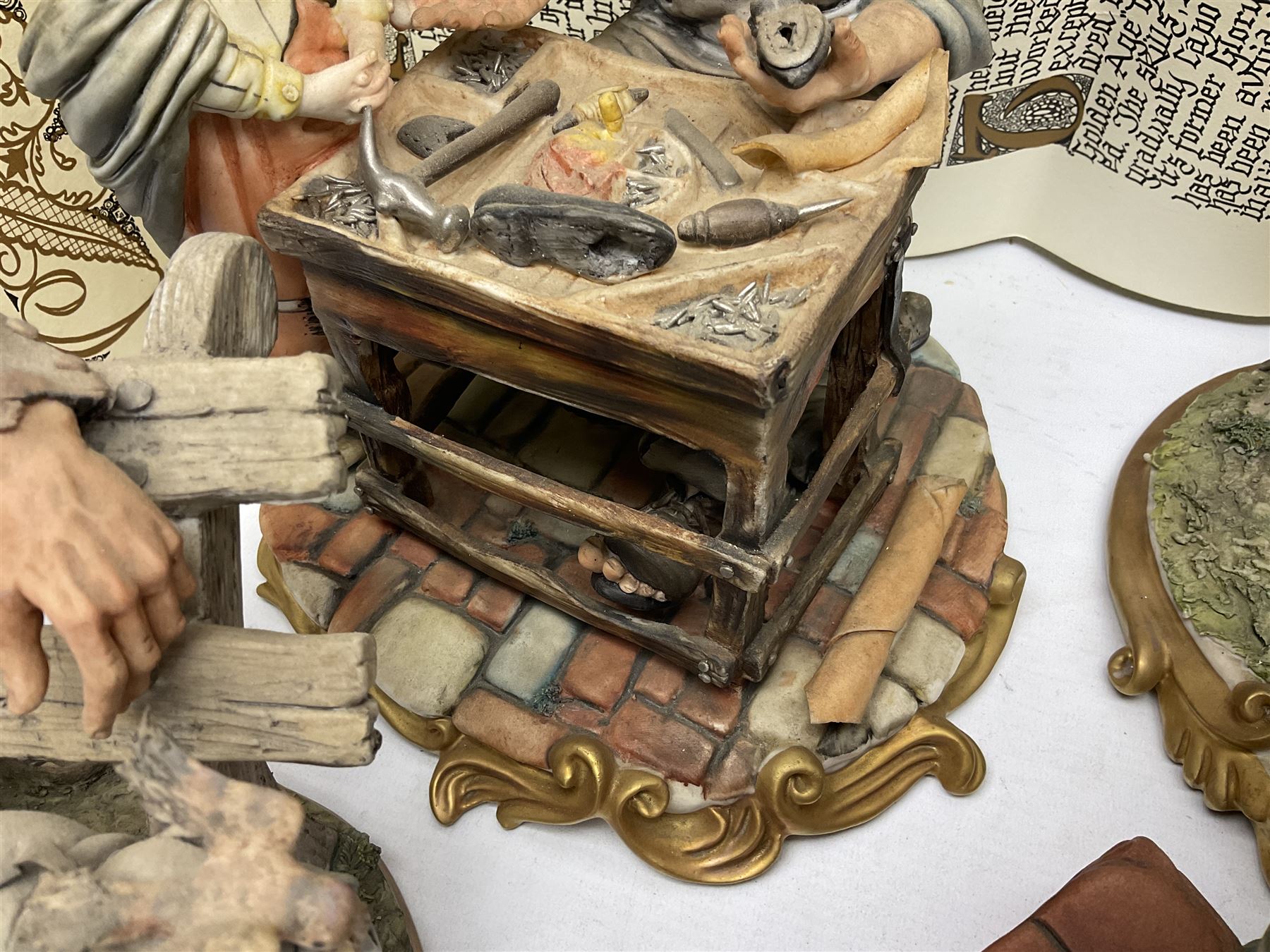 Four Capodimonte figure groups, to include tramp figures, shoemaker figure etc