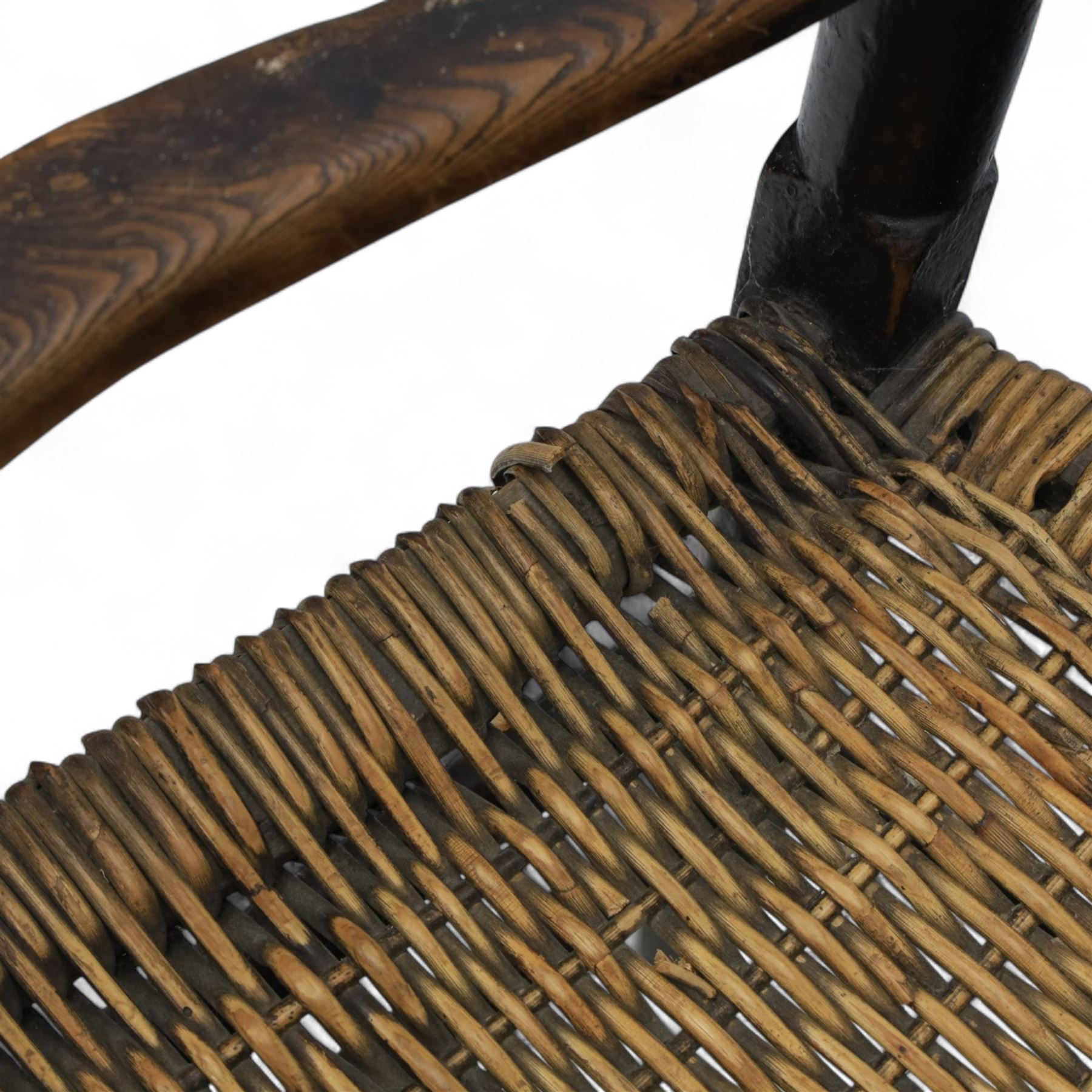 19th century country elm spindle back armchair, shaped cresting rail over two rows of turned spindles, shaped open arms over rush seat, on front turned supports, joined by stretchers 
