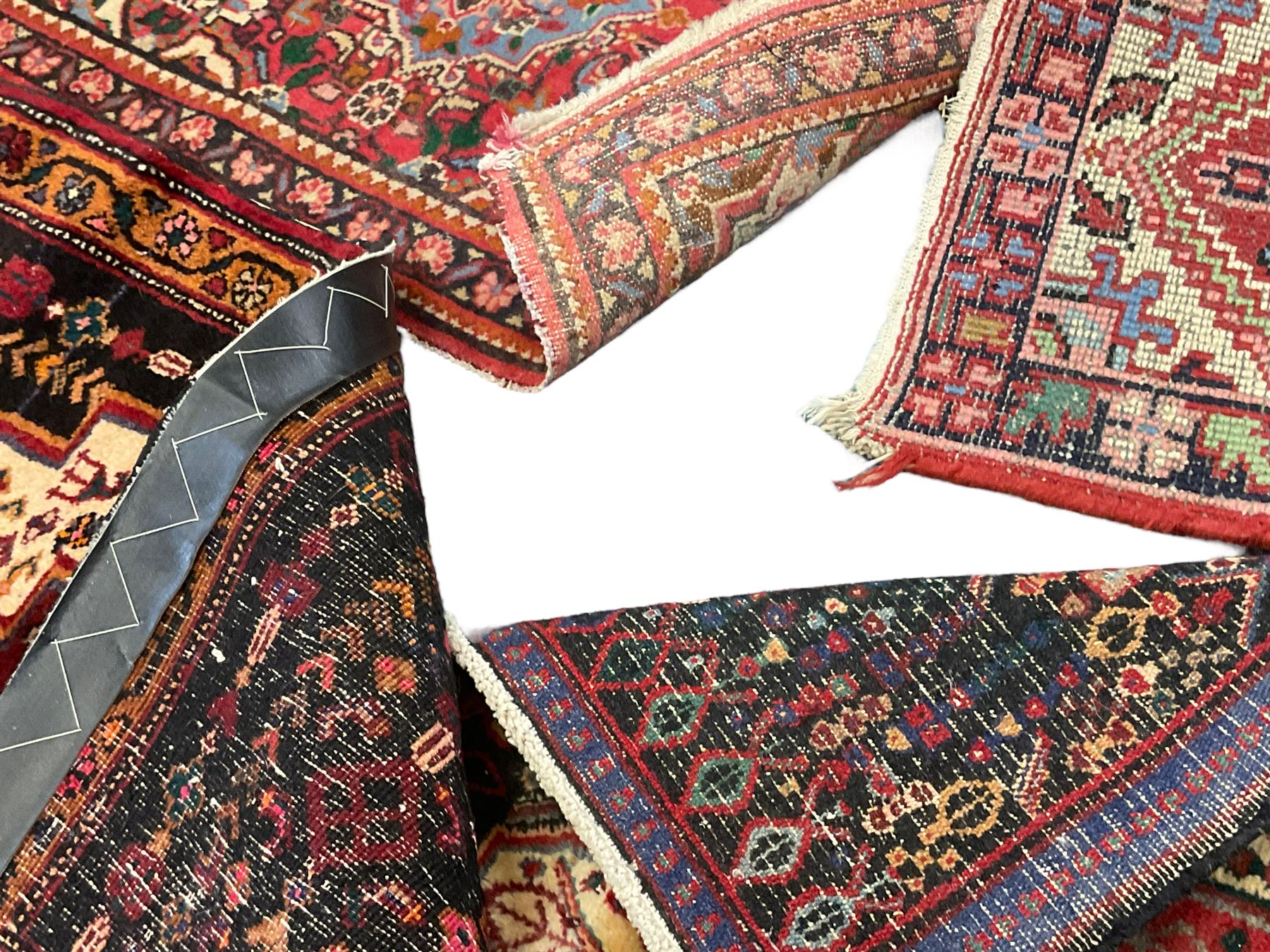 Small Hamadan dark indigo ground rug, central ivory and maroon lozenge with geometric decoration, guarded border with repeating stylised plant motifs, together with three others (4)